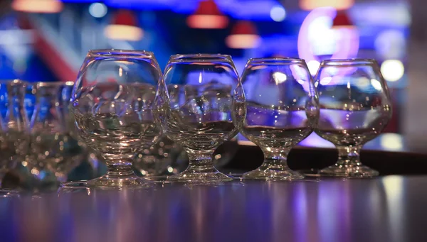 Glasses on an arm over bar counter — Stock Photo, Image