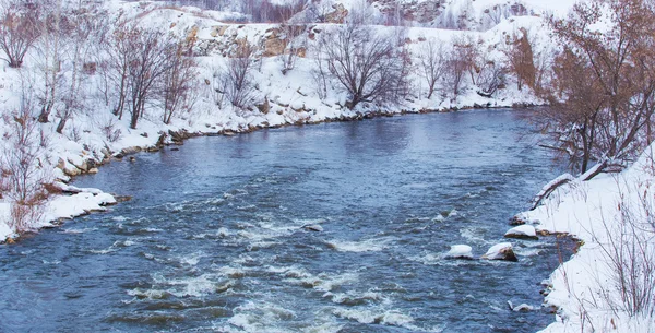Заснеженный берег реки зимой — стоковое фото