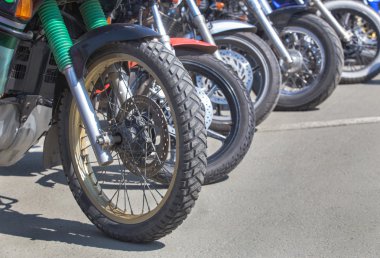 Motorsikletler asfaltta park halindeler.