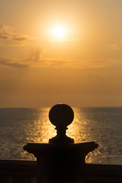 Apoyo con esfera contra la puesta del sol del mar — Foto de Stock