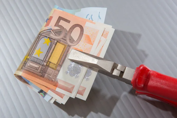 Billetes en euros sujetados con pinzas de nariz plana —  Fotos de Stock