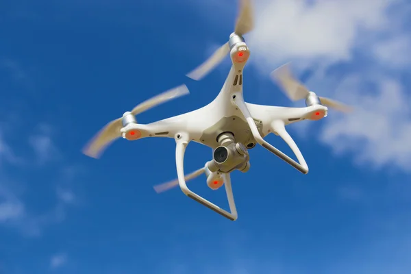 Flying quadcopter in blue sky — Stock Photo, Image