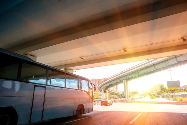 Autobús se mueve bajo el puente en la carretera — Foto de Stock