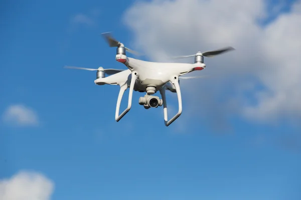 Flying quadcopter in blue sky — Stock Photo, Image