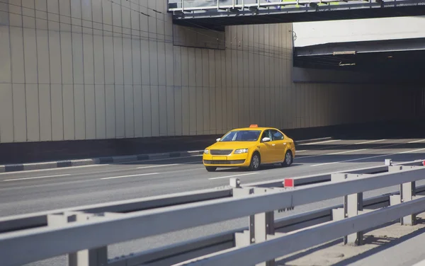 Táxi amarelo se move sobre a cidade — Fotografia de Stock