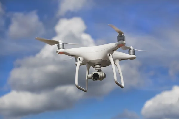 Flying quadcopter in blue sky — Stock Photo, Image