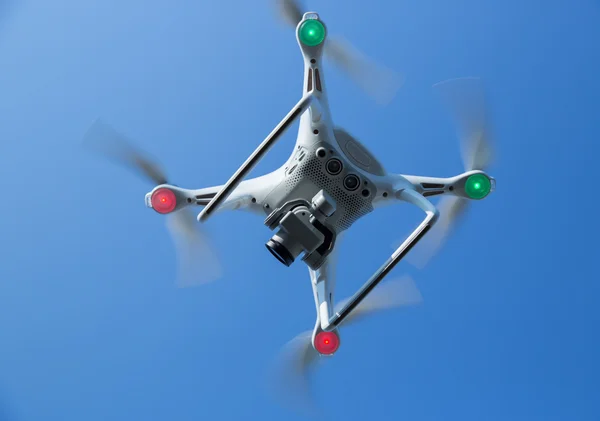 Flying quadcopter in blue sky — Stock Photo, Image