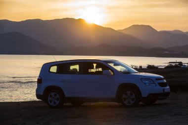 Gün batımında arabayla deniz kenarında tatil.