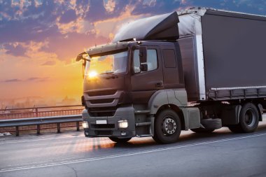 Kamyon gün batımında otoyola çıkıyor.