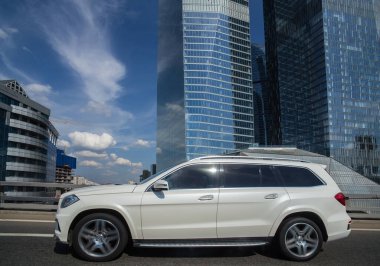 SUV köprüden geçip modern gökdelenleri geçiyor.