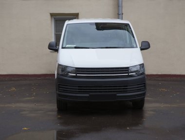 Minivan evin duvarının yanındaki otoparkta.