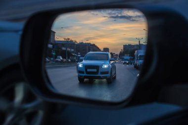 Bir şehir caddesinde araba trafiğinin dikiz aynasından bak.
