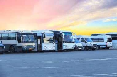 Otobüs durağının otoparkında gün batımında güzel bir gökyüzünün arka planında.