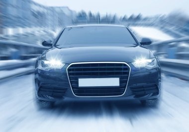 Siyah araba kış yolunda ilerliyor.