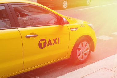 Sarı taksi şehir caddesinde ilerliyor.