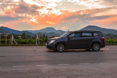 Araba, üzüm bağları boyunca dağlarda yolda ilerliyor..