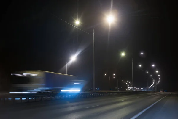 Truck traffic on a winter highway at night