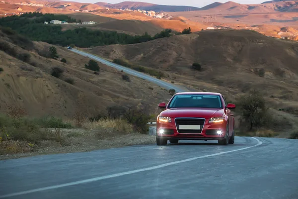 夏の夜に曲がりくねった山道に沿って赤い車のドライブ — ストック写真
