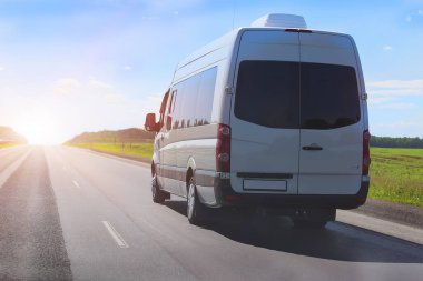 Minibüs orman boyunca otoyola çıkıyor.