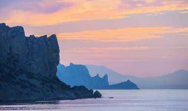 Deniz kıyısındaki kayaların üzerinde güzel bir gün doğumu.