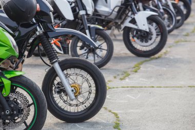 Motorsikletler asfaltta park halindeler.
