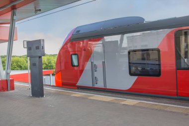 Modern kırmızı tren tren tren istasyonuna yaklaşıyor.