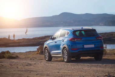 Dağların yakınındaki deniz kıyısında bir cip. Bir aileyle doğaya, denize arabayla gitmek..