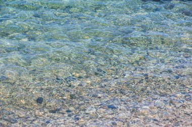 Deniz kıyısında su altında çok güzel çakıl taşları var. Arkaplan