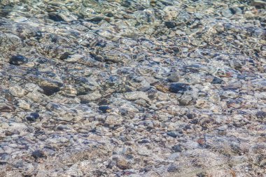 Deniz kıyısında su altında çok güzel çakıl taşları var. Arkaplan
