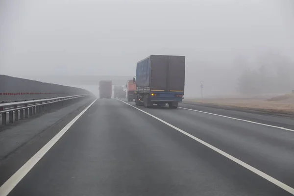 Φορτηγά Κινούνται Στην Ομίχλη Στην Εθνική Οδό Των Προαστίων — Φωτογραφία Αρχείου