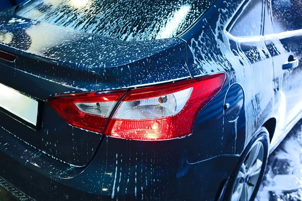 Coche cubierto con espuma en el lavado de coches — Foto de Stock