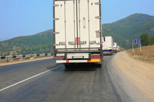 Camiones se mueven en carretera de montaña — Foto de Stock