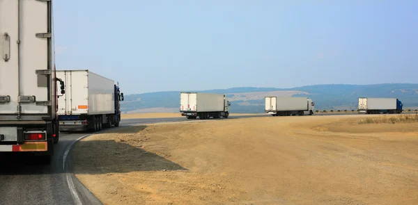 Camiones se mueven en carretera de montaña — Foto de Stock