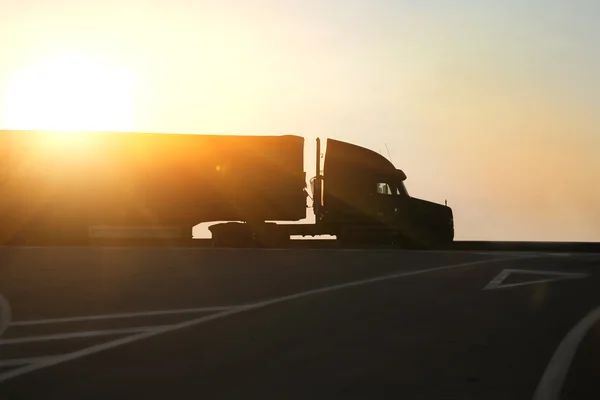 Samochód idzie na autostradzie na zachód słońca — Zdjęcie stockowe