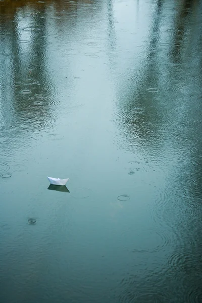 雨にぬれたアスファルトに折り紙ボート — ストック写真