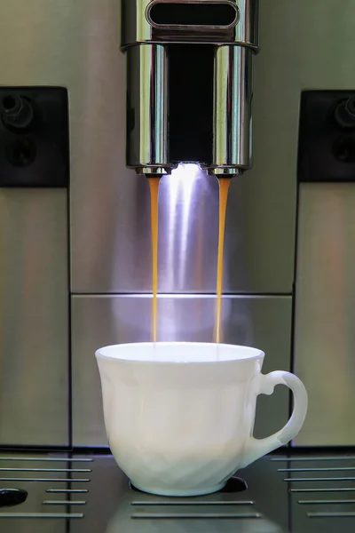 Кавоварка п'є каву в чашку — стокове фото