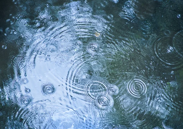 Gotas de lluvia cayendo en la piscina — Foto de Stock
