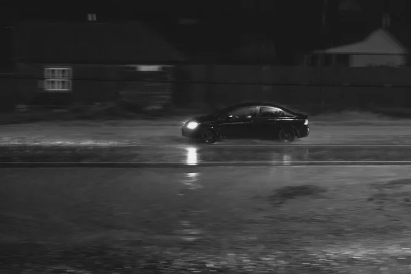 Coche va por la noche a la lluvia en la carretera —  Fotos de Stock