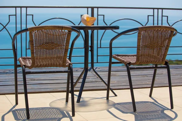 Krzesła i stół na terassa przez morze — Zdjęcie stockowe