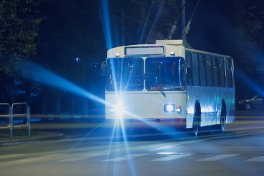 trolleybus goes at night down street clipart