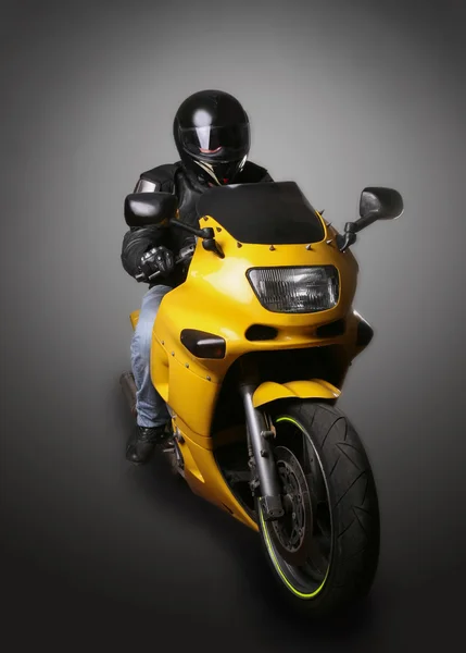 Motorradfahrer mit Helm auf gelbem Motorrad — Stockfoto