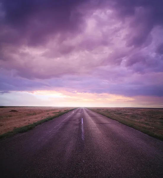 Tramonto in cielo nuvoloso su strada — Foto Stock