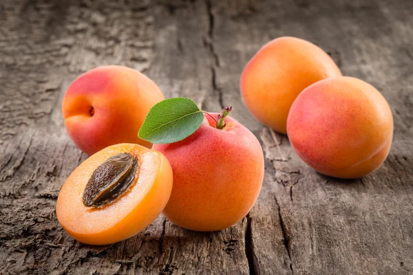 Aprikose. Bio-Früchte mit Blatt auf Holzgrund — Stockfoto