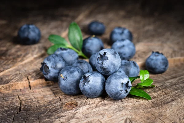 Blaubeere mit Blättern auf Holzgrund — Stockfoto