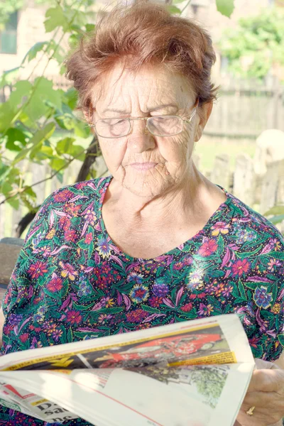 Mulher idosa ler jornal — Fotografia de Stock