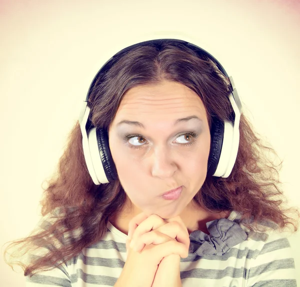 Mujer con expresión sospechosa y auriculares — Foto de Stock