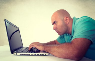 Bald man looking at the laptop clipart