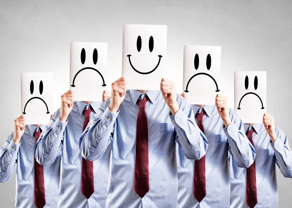 Affärsmän håller papper med glad och negativa symboler — Stockfoto