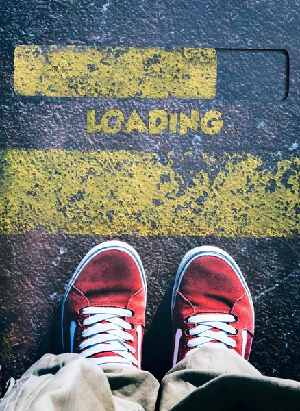 Mans legs behind loading sign — Stock Photo, Image