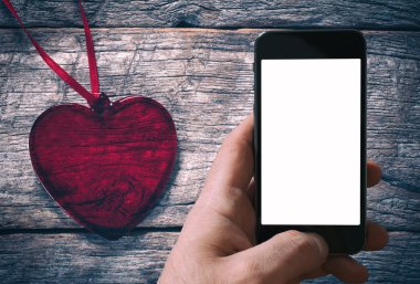 Boş yer üstünde hareket eden telefon ile kırmızı kalp